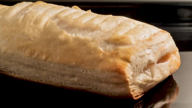 Timelapse - puff pastry bun with apple jam baking and rising on tray in electric oven in kitchen at home - close up view. Homemade bakery, food, cooking, pastry and time lapse concept