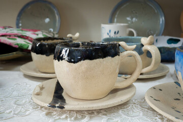 Multi-colored handmade ceramic bowls and cups covered with glaze in the pottery workshop