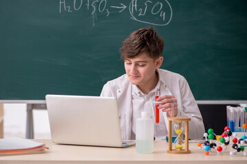 Schoolboy studying chemistry in the classroom