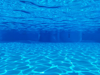 The view through a viewing port between floor, bottom and surface of luxury swimming pool and blue...