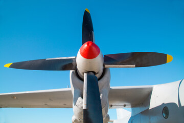 The propeller of the aircraft is blue and red against the blue sky on a clear sunny day Military...