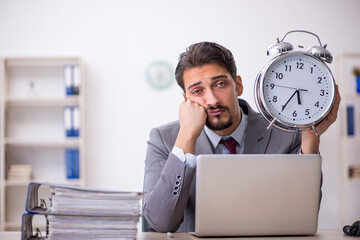 Young male employee in time management concept