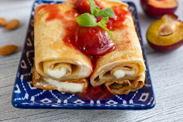Pancakes with vanilla yogurt and stewed plums.