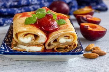 Pancakes with vanilla yogurt and stewed plums.