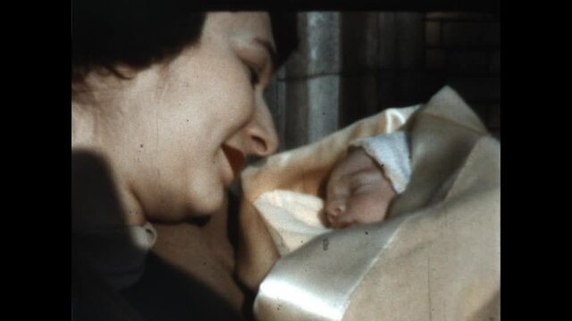Angelic Baby 1951 - A mother smiles at her newborn baby.  