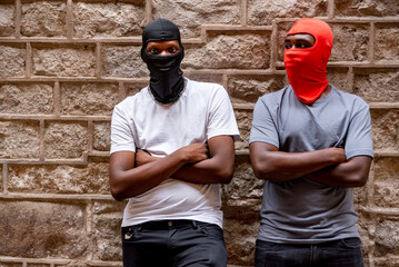 Two afro young men in ski masks in alleyway