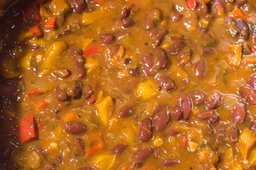 beans with vegetables and yellow sauce in an aluminum pan