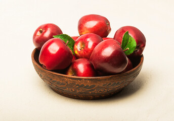 Ripe red apples in a bowl on the table.