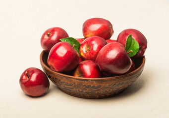 Ripe red apples in a bowl on the table.