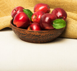 Ripe red apples in a bowl on the table.