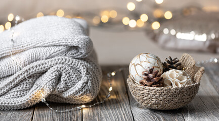 Cozy winter bokeh background with stacked sweaters and decor details.