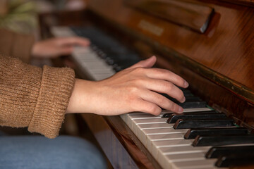 Close-up of female hands playing the piano.