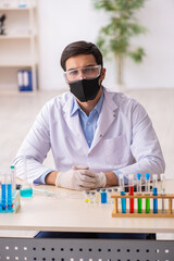 Young male chemist working at the lab during pandemic