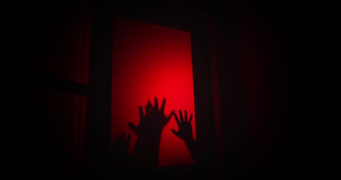 Creepy hands drag down a window in distress