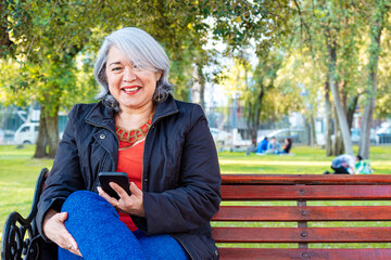 Mature woman using the smart phone at a park