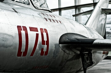 antique war fighter plane in a museum with red numbers and stars