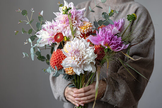 Close-up of a bright festive bouquet with chrysanthemums in female hands.
