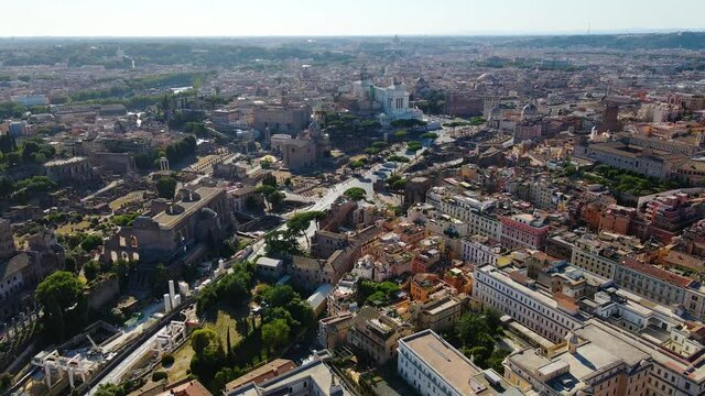 Aerial view over the cityscape towards the Santa Maria in Aracoeli church in sunny Rome, Italy - tilt, drone shot