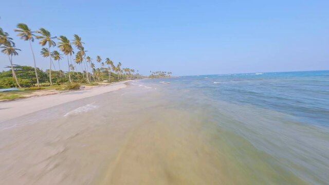 Aerial drone fpv over transparent waters of Los Coquitos beach. Dominican Republic