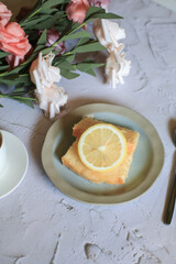 Lemon pound cake with slices of lemon and cup of coffee. Rose flower with dessert. Delicious breakfast, traditional. Vintage concept.
