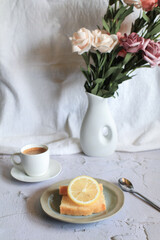 Lemon pound cake with slices of lemon and cup of coffee. Rose flower with dessert. Delicious breakfast, traditional. Vintage concept.