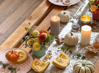 Festive table setting with pumpkins and chrysanthemum flowers.