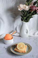 Lemon pound cake with slices of lemon and cup of coffee. Rose flower with dessert. Delicious breakfast, traditional. Vintage concept.