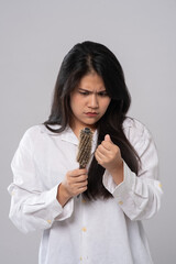 Portrait  of asian woman long hair with a comb and problem hair on white background. This image for...