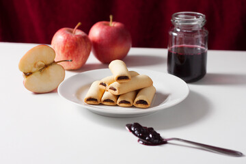 Apple filled biscuits and a jar of blueberry jam. Blueberry jam on a spoon.