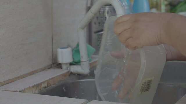 Mujer lavando los platos argentina agua corriente canilla