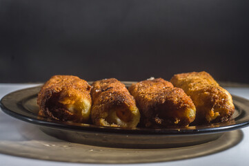 Fried dumplings with cheese, selective focus, copy space and black background