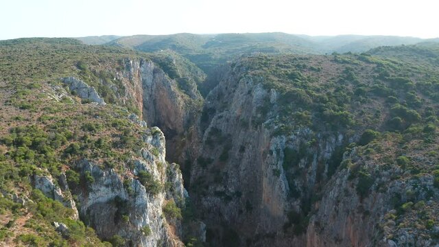 Rocky canyon reveal shot of Palaiochora Kythira Castle, Greece