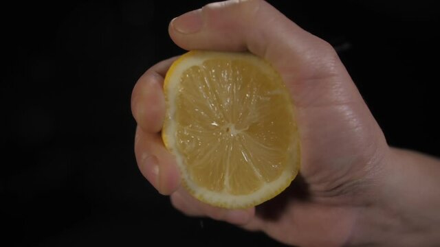 hand squeezing lemon slow motion