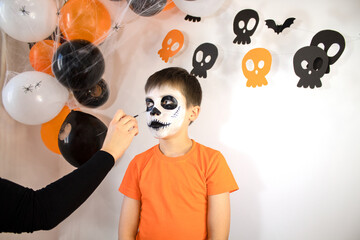 Happy boy preparing for Halloween. The boy gets a skeleton makeover for the holiday