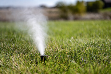 winterizing a irrigation sprinkler system by blowing pressurized air through to clear out water - obrazy, fototapety, plakaty