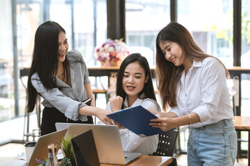 Teamwork collaboration of young Asian businesswomen to achieve goals at the office.