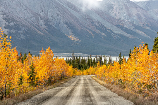 Road trip, tourism, travel themed shot heading directly towards huge mountain landscape in fall, autumn during September in northern Canada, Yukon Territory. 