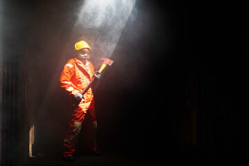 Brave Firefighter holding axe during battle a fire with mission successful for protect with...