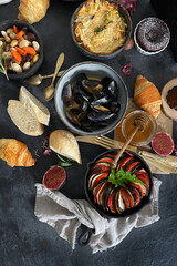 French dishes and appetizers served on dark background.