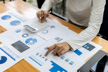 A financial scholar is pointing at a document with a pen, she is analyzing and checking company financial data for accuracy before presenting it to the meeting. Financial audit concept.