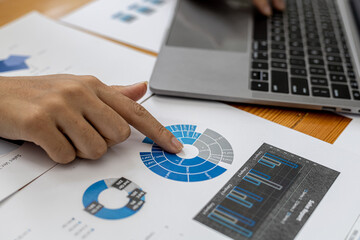 A businesswoman is checking company financial documents and using a laptop to talk to the chief financial officer through a messaging program. Concept of company financial management.
