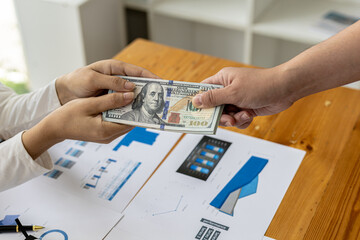 Picture of two people handing over a dollar, they are business partners who are doing corrupt...