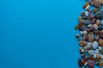 Flat lay composition sea pebbles on a blue background. space for text