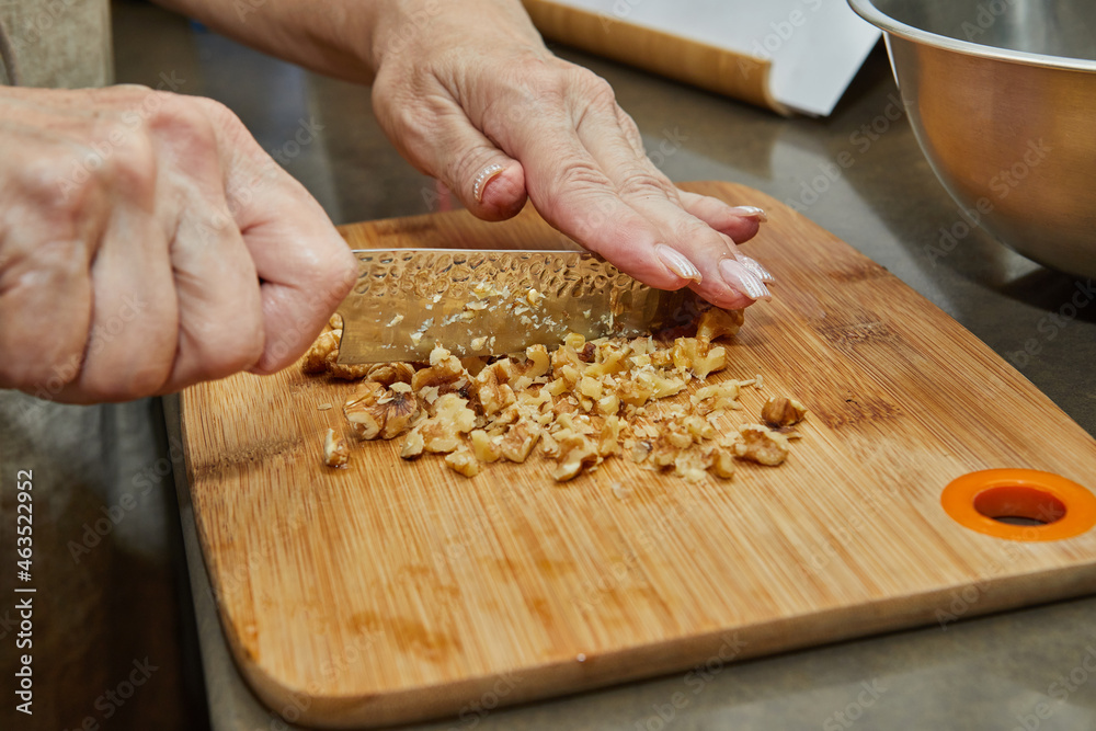 Poster Chef grinds nut with knife to add to the salad. Step by step recipe