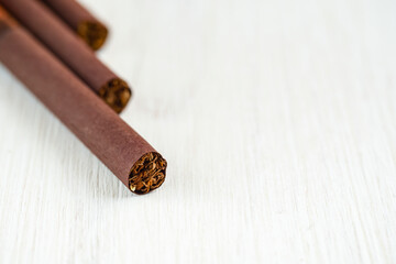Cigarettes in brown paper on a white background close-up