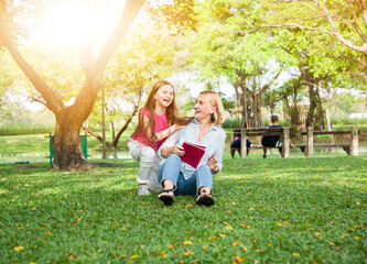 Mother and her daughter playing in the garden in summer day, family concept