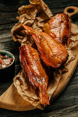 Appetizing smoked fish. Hot smoked river bass fish on a wooden background. vertical image. top view. place for text