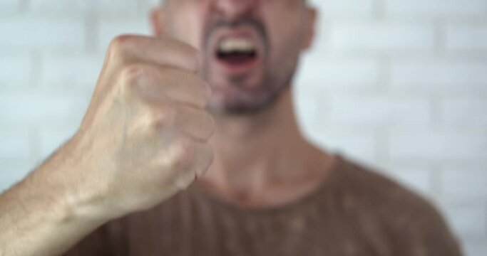 Screaming man at home. A view of screaming aggressive man staying in the room.