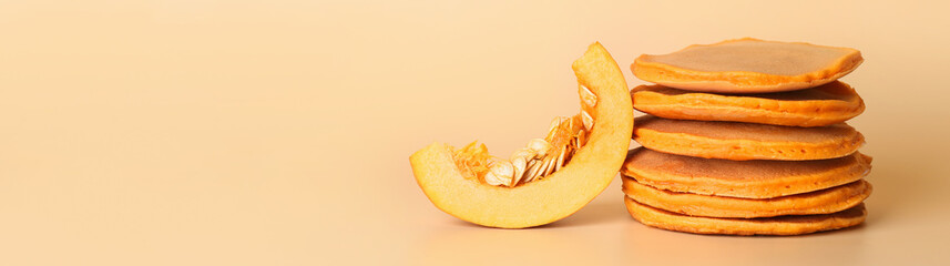 Tasty pumpkin pancakes on color background with space for text