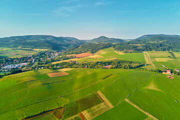 Village near mountain and agricultural fields at sunset. Nature landscapem aerial view